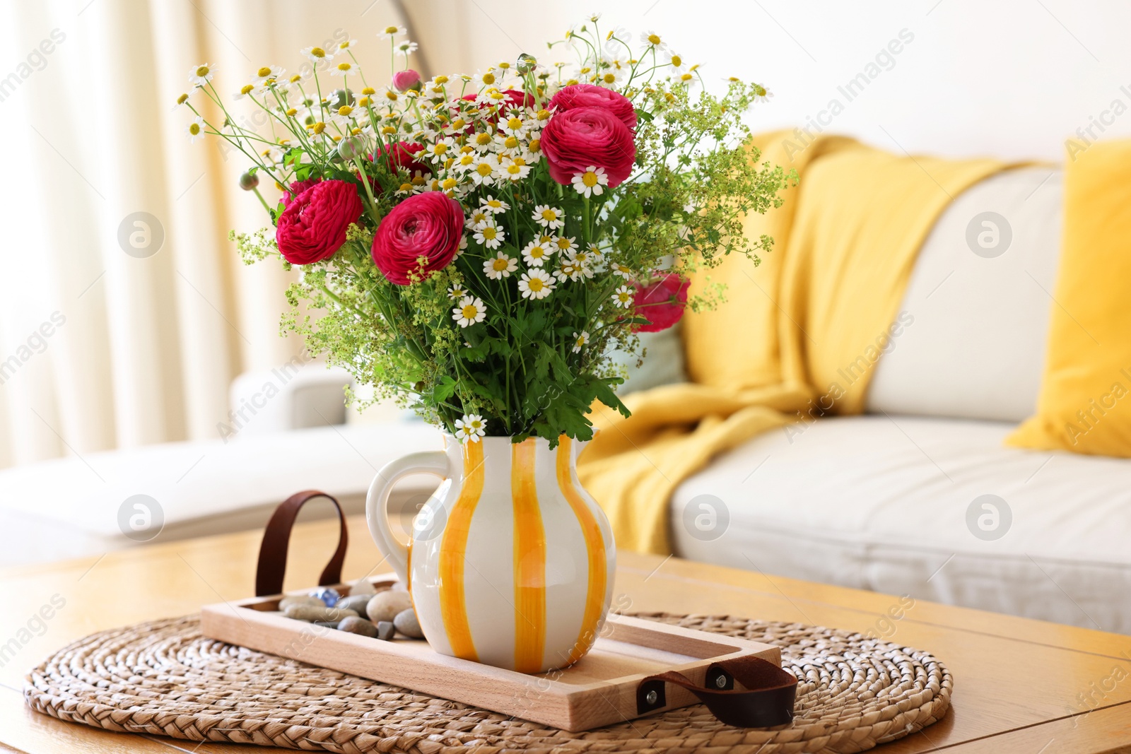 Photo of Beautiful ranunculus flowers and chamomiles in vase on table indoors