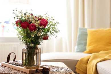 Photo of Beautiful ranunculus flowers and chamomiles in vase on table indoors