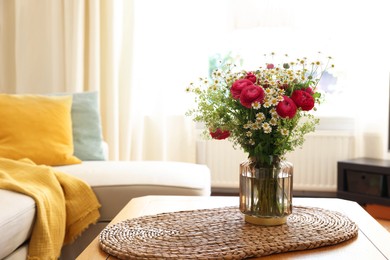 Photo of Beautiful ranunculus flowers and chamomiles in vase on table indoors