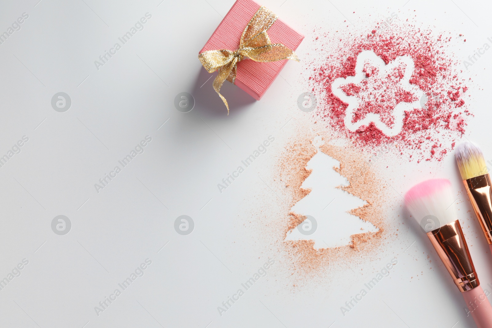 Photo of Christmas decorations made of powder and blush, gift box and makeup brushes on white background, flat lay. Space for text