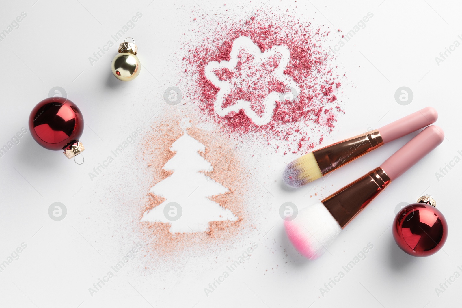 Photo of Christmas decorations made of powder and blush, makeup brushes and balls on white background, flat lay