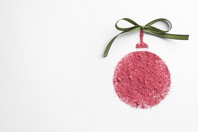 Photo of Christmas ball made of blush with bow on white background, top view. Space for text