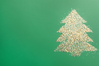 Photo of Christmas tree made of glitter on green background, top view. Space for text