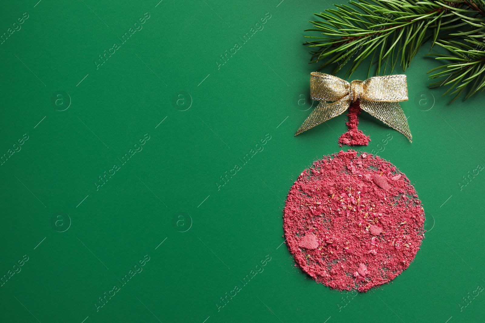 Photo of Christmas ball made of blush with bow and fir branch on green background, top view. Space for text