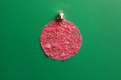 Photo of Christmas ball made of blush on green background, top view