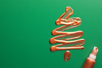 Photo of Christmas tree drawn of cosmetic product on green background, top view. Space for text