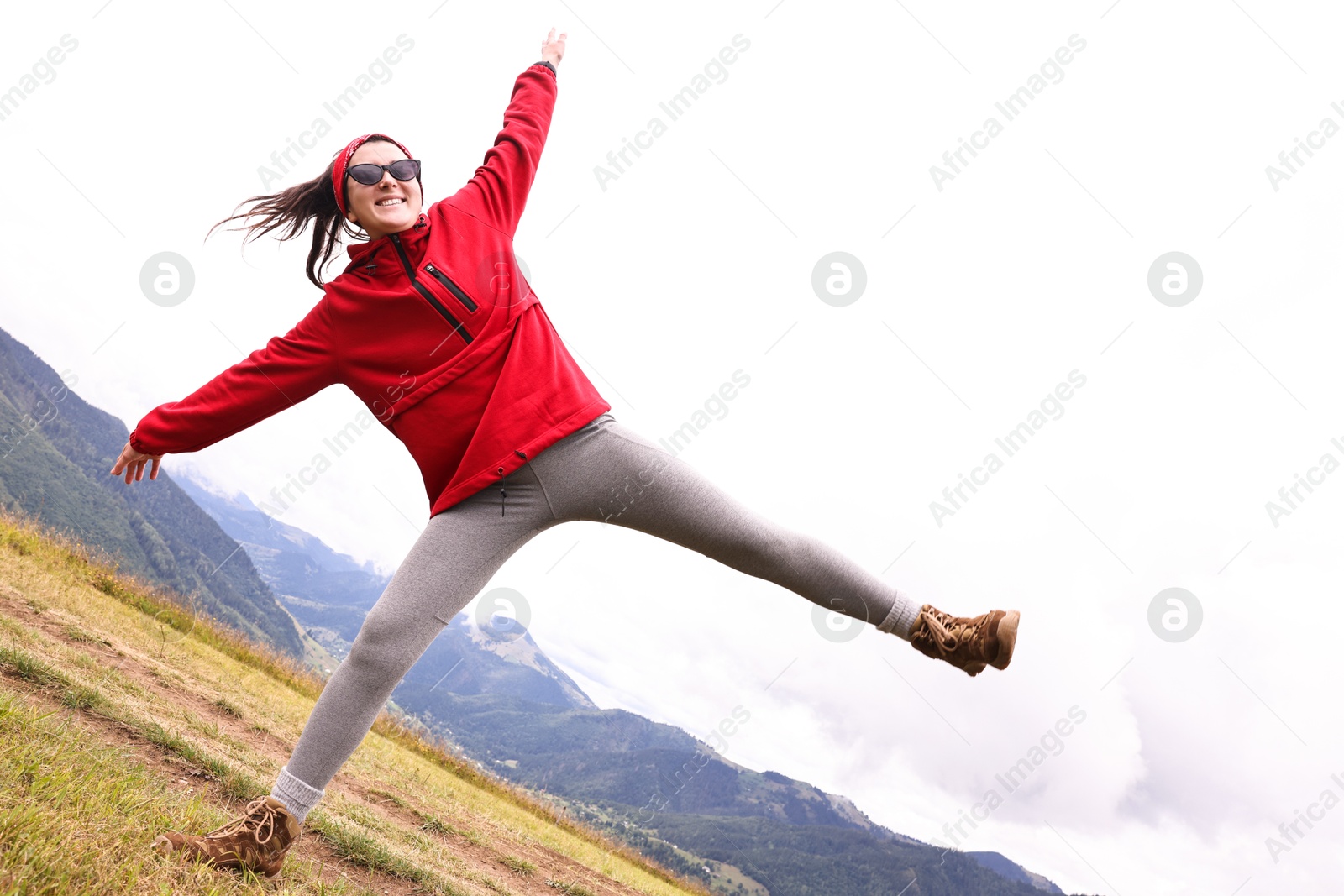 Photo of Happy young hiker in mountains, low angle view