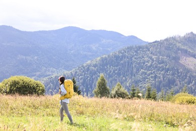 Young woman with backpack hiking in mountains