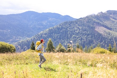 Young woman with backpack hiking in mountains