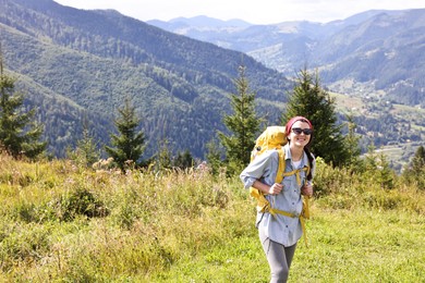 Photo of Happy young hiker with backpack in mountains