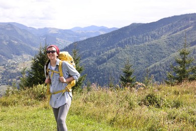 Photo of Happy young hiker with backpack in mountains