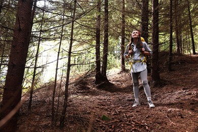 Photo of Young hiker with backpack enjoying time in forest