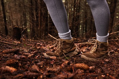 Photo of Hiker with trekking shoes in forest, closeup