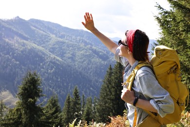 Photo of Young hiker with backpack in mountains on sunny day