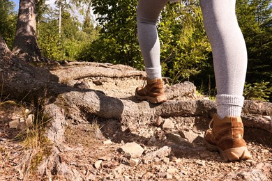 Young hiker in trekking shoes walking outdoors, closeup