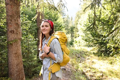 Young hiker with backpack enjoying time in forest