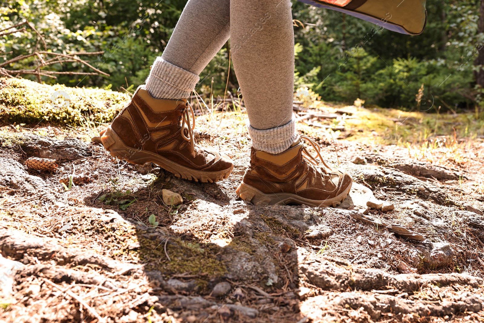 Photo of Young hiker in trekking shoes walking outdoors, closeup