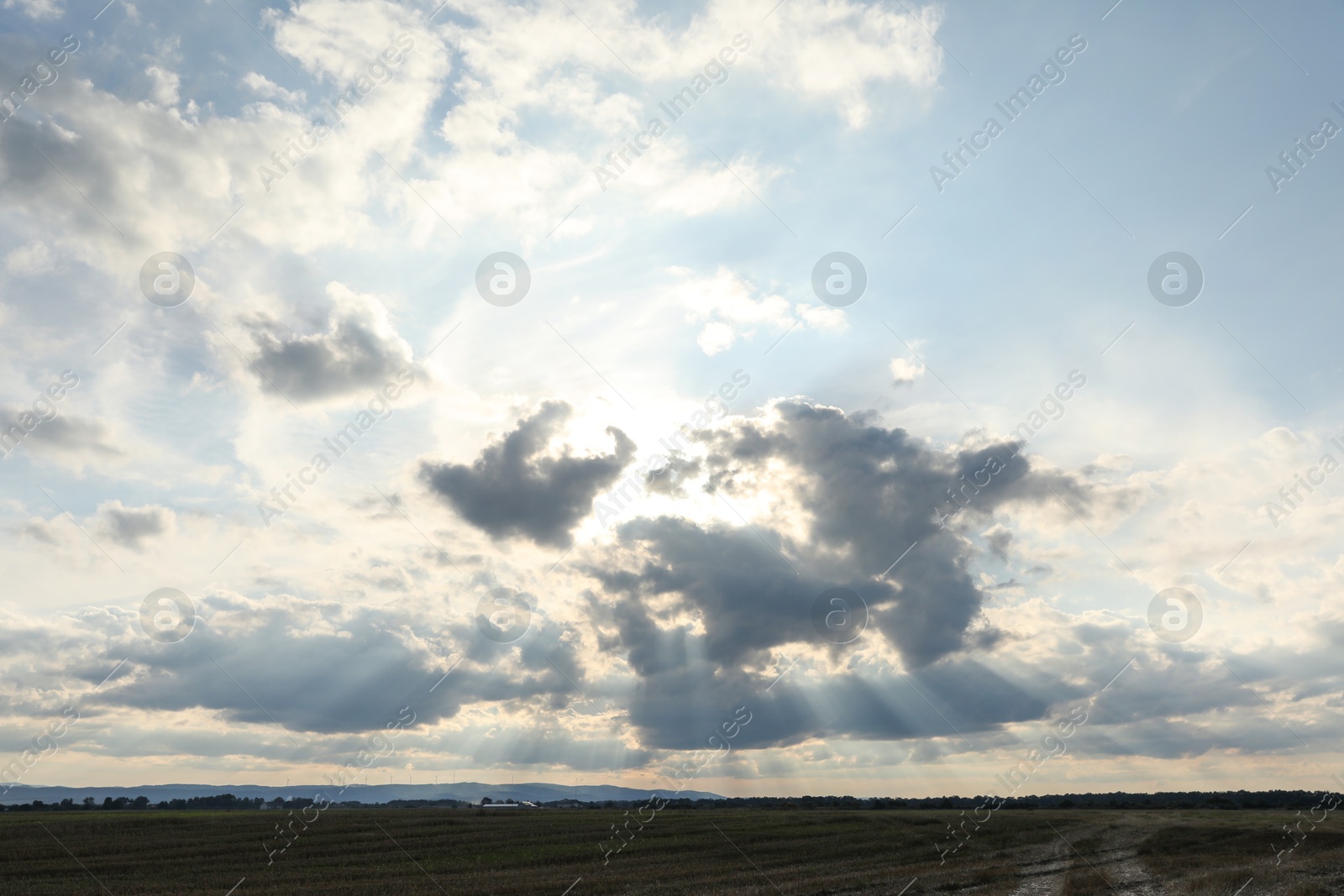 Photo of Sun shining through clouds on beautiful sky