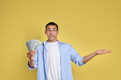 Photo of Man with dollar banknotes on yellow background