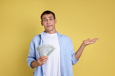 Photo of Man with dollar banknotes on yellow background