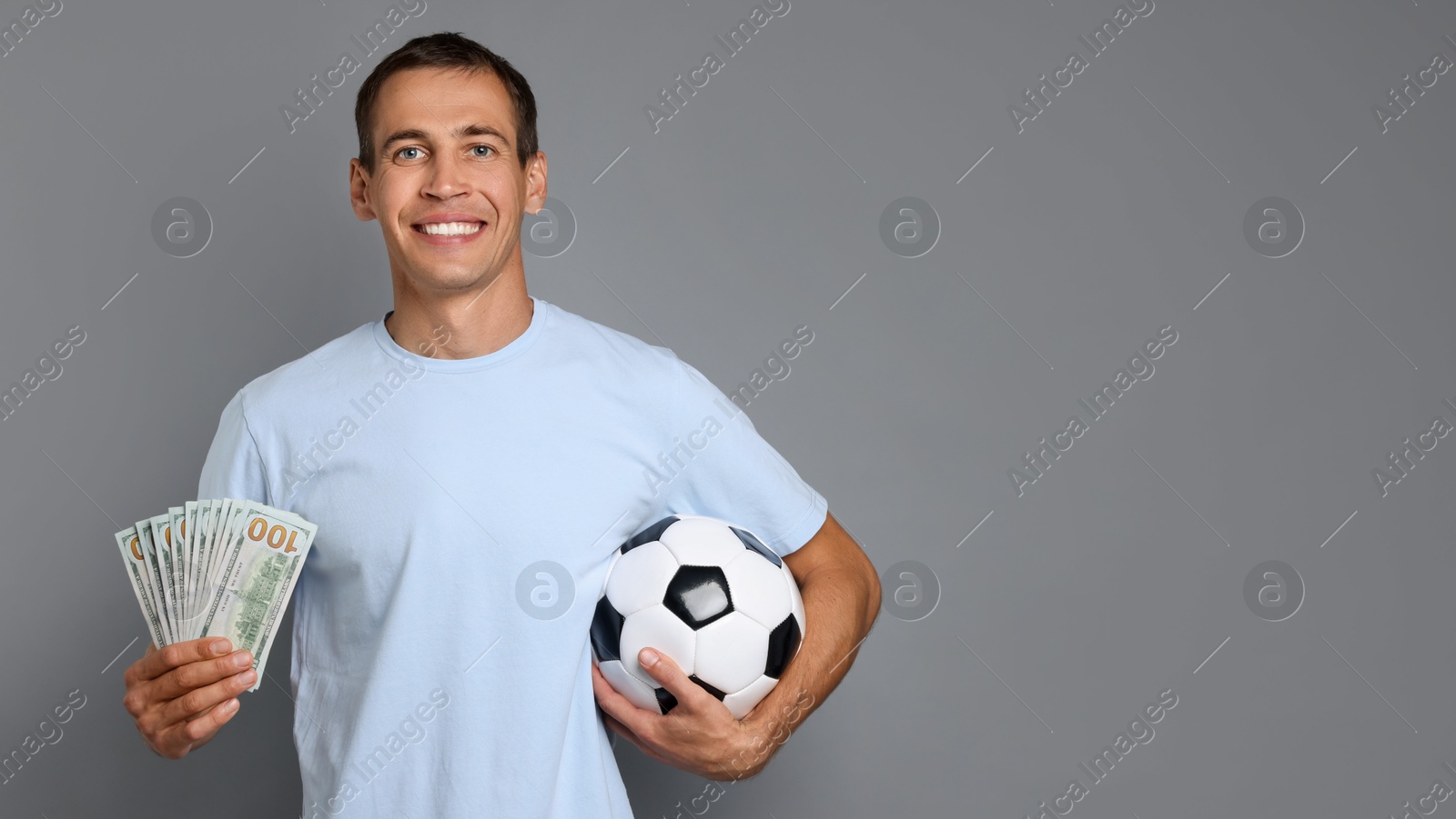 Photo of Man with money and soccer ball on grey background, space for text