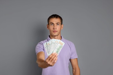 Photo of Man with dollar banknotes on grey background