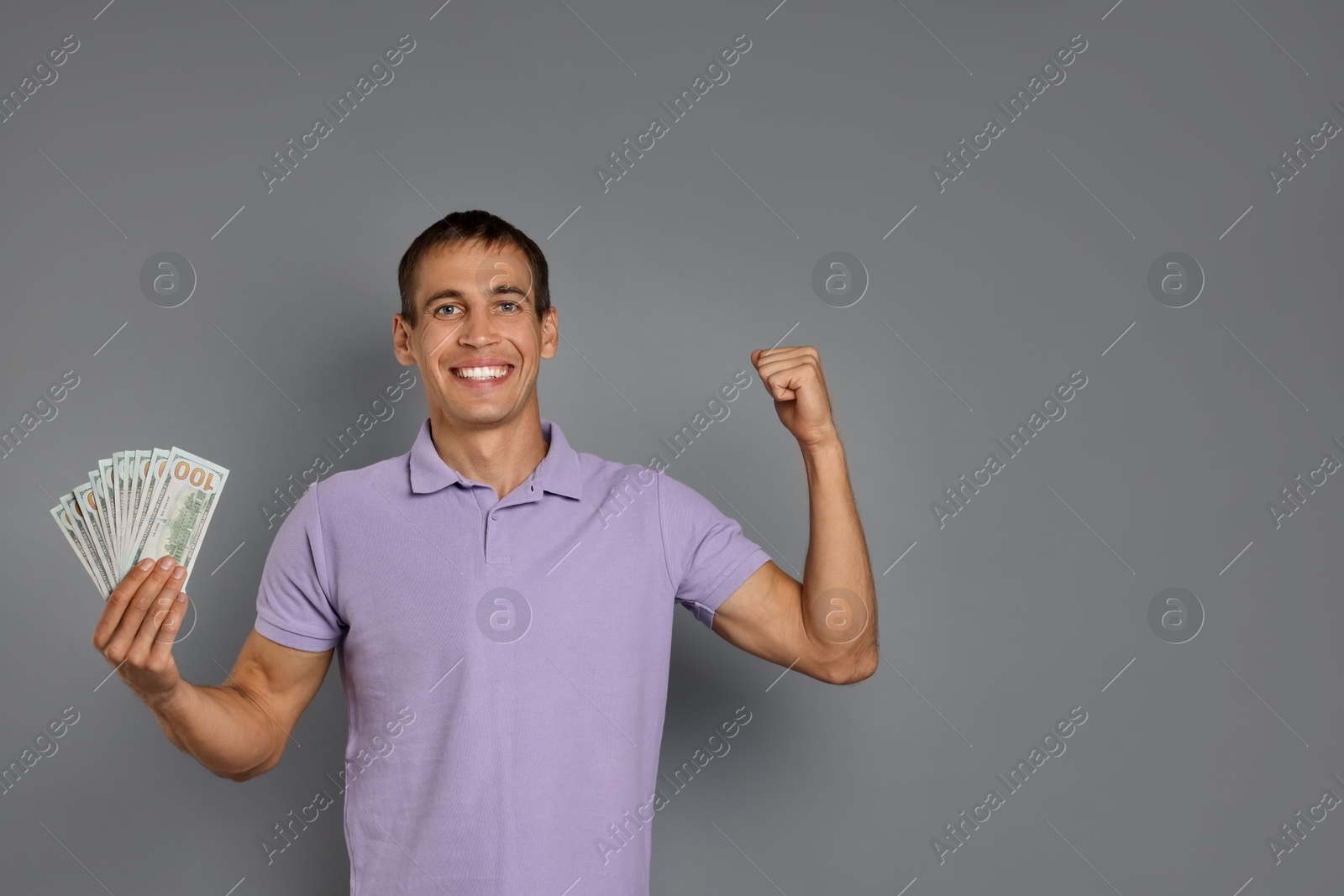 Photo of Happy man with money on grey background, space for text