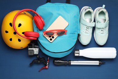 Photo of Flat lay composition with bicycle accessories on blue wooden background