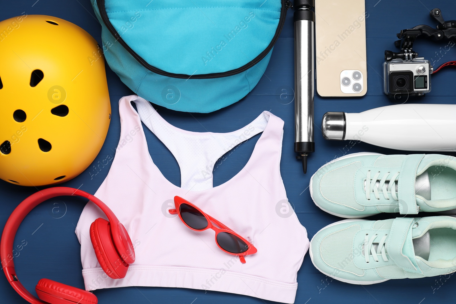 Photo of Flat lay composition with bicycle accessories on blue wooden background