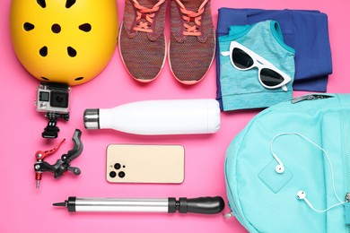 Flat lay composition with bicycle accessories on pink background