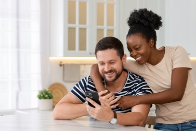 Photo of International relationships. Lovely couple spending time together in kitchen