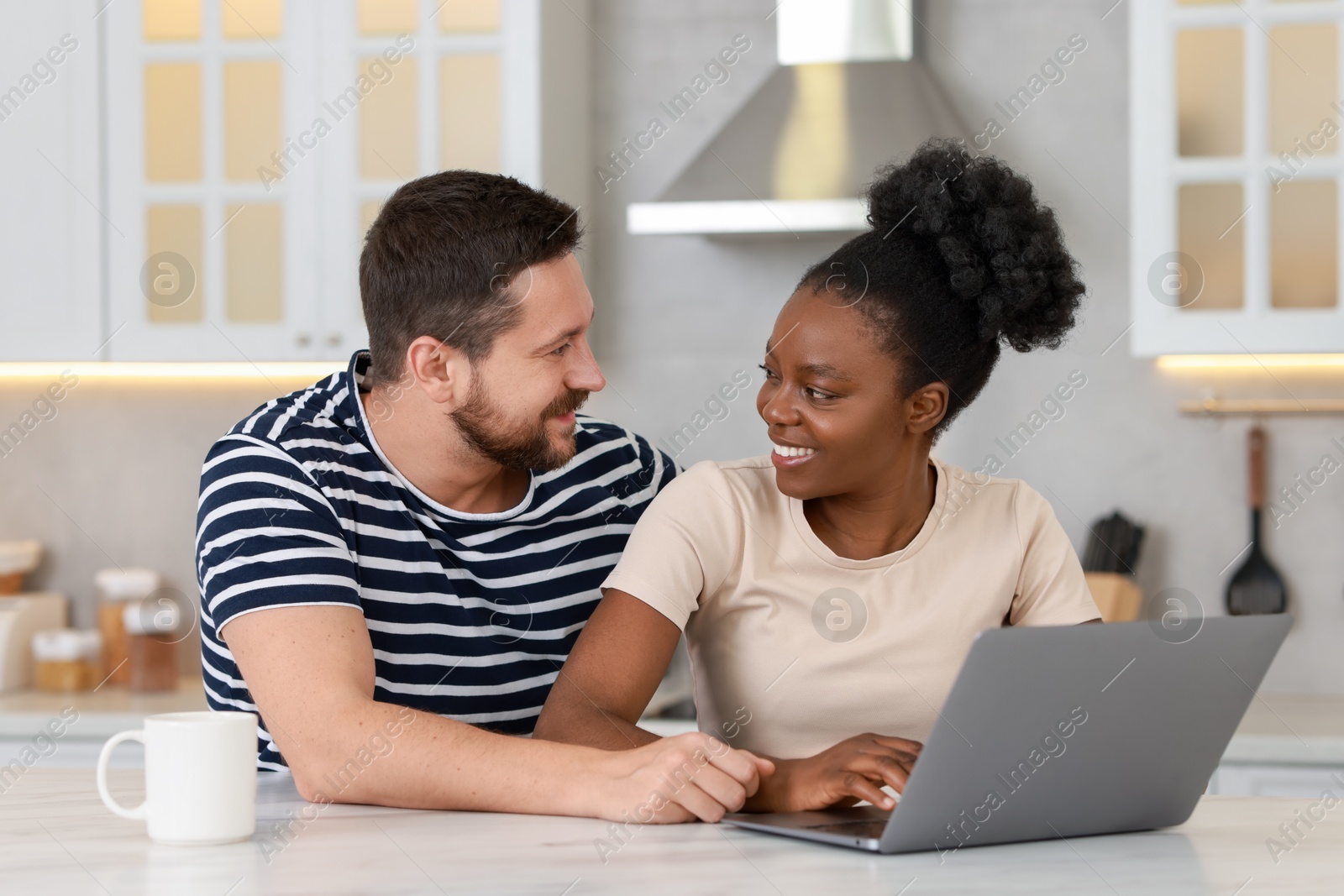 Photo of International relationships. Lovely couple spending time together in kitchen