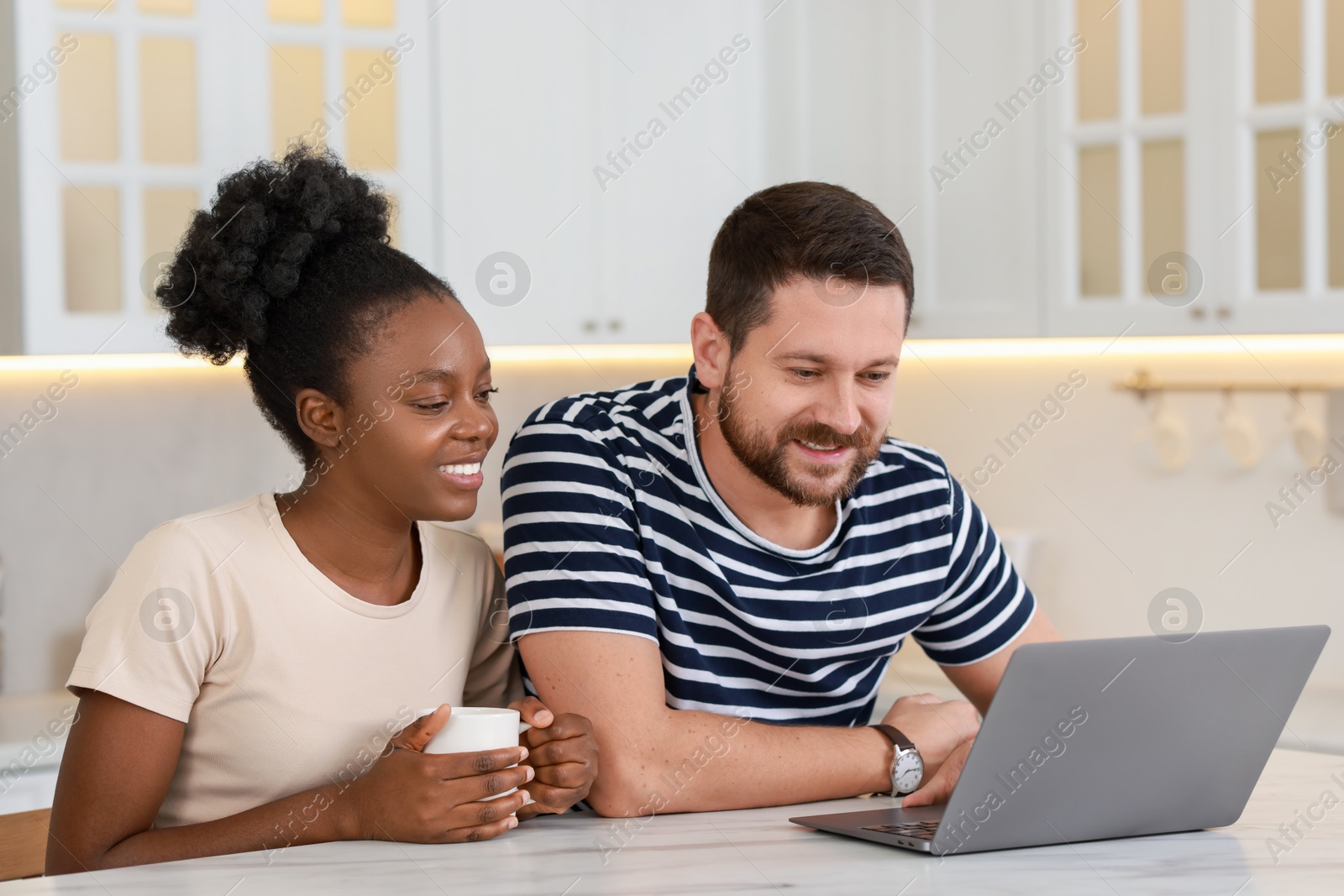 Photo of International relationships. Lovely couple spending time together in kitchen