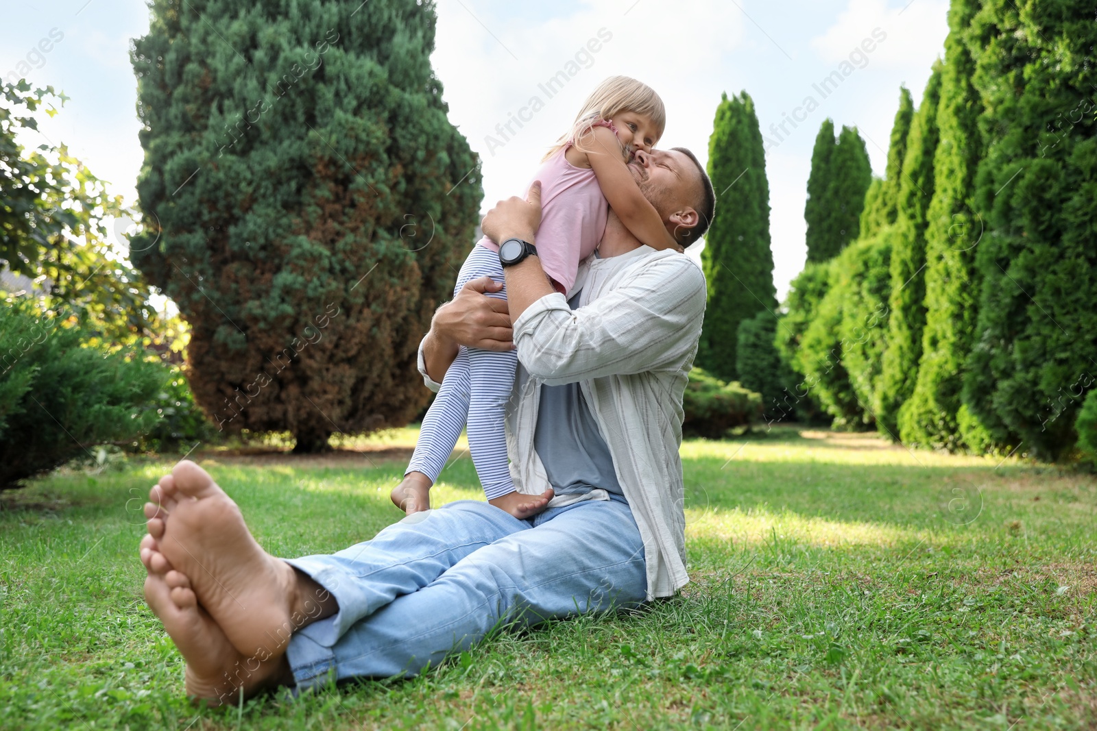 Photo of Father and his daughter spending time together on green lawn in park