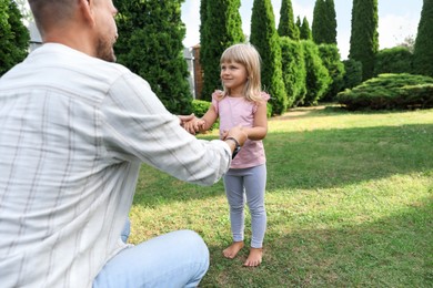 Photo of Father and his daughter spending time together on green lawn in park