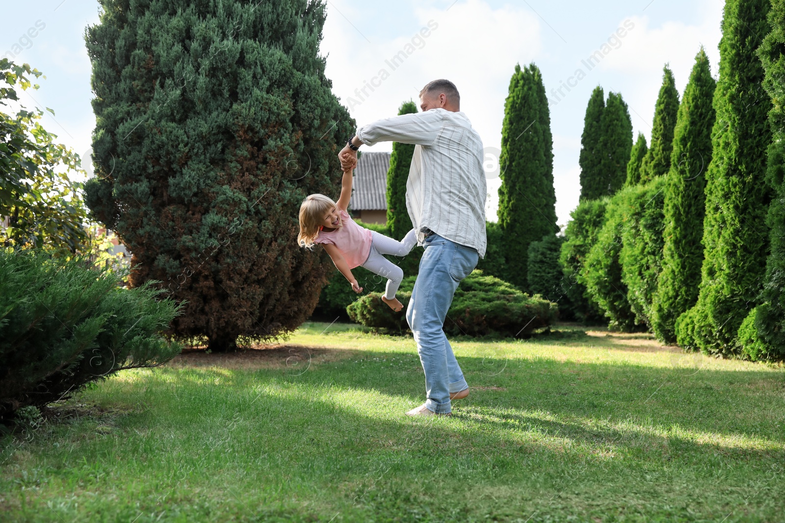 Photo of Father and his daughter spending time together on green lawn in park