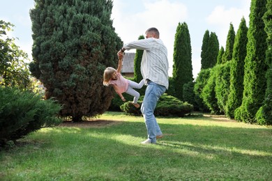 Photo of Father and his daughter spending time together on green lawn in park