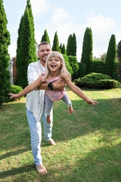 Photo of Father and his daughter spending time together on green lawn in park