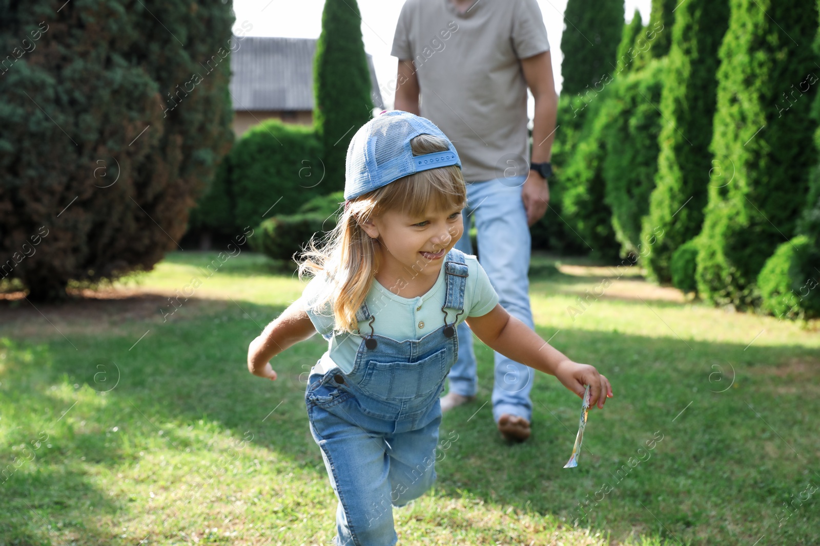 Photo of Father and his daughter spending time together on green lawn in park