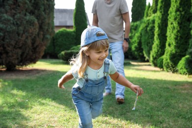 Photo of Father and his daughter spending time together on green lawn in park