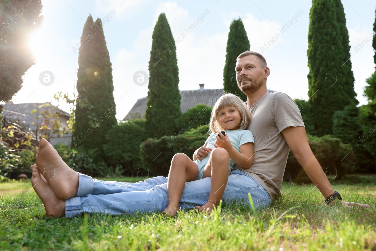 Photo of Father and his daughter spending time together on green lawn in park