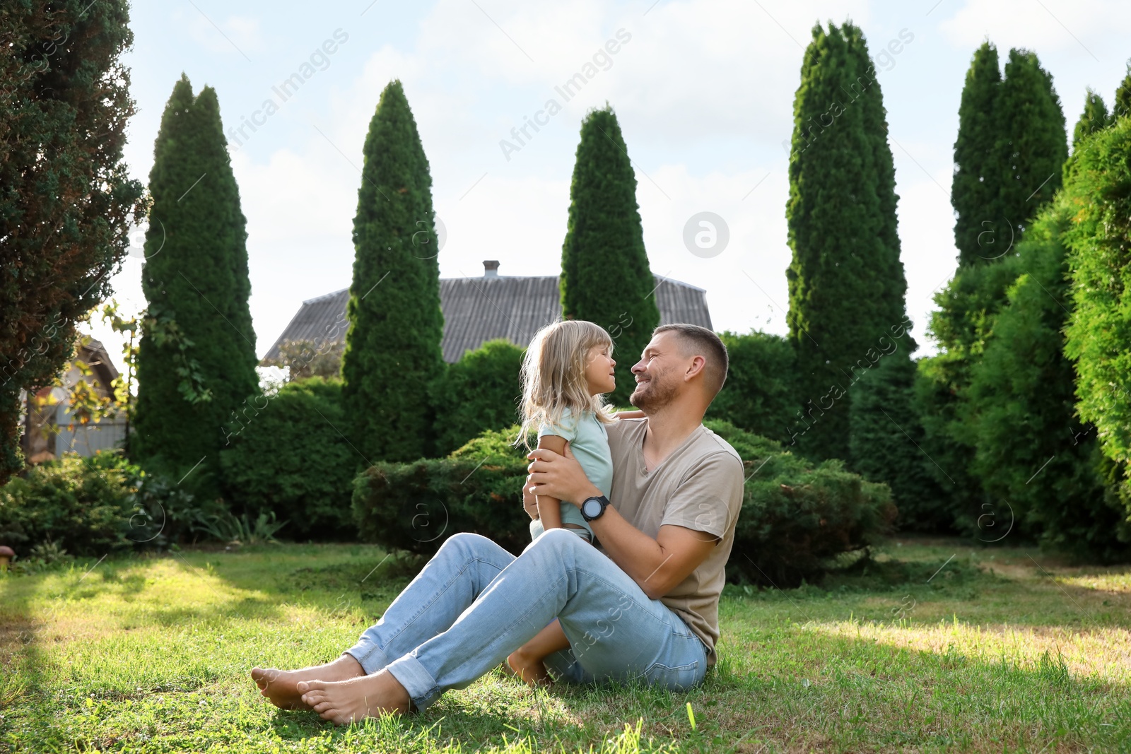 Photo of Father and his daughter spending time together on green lawn in park