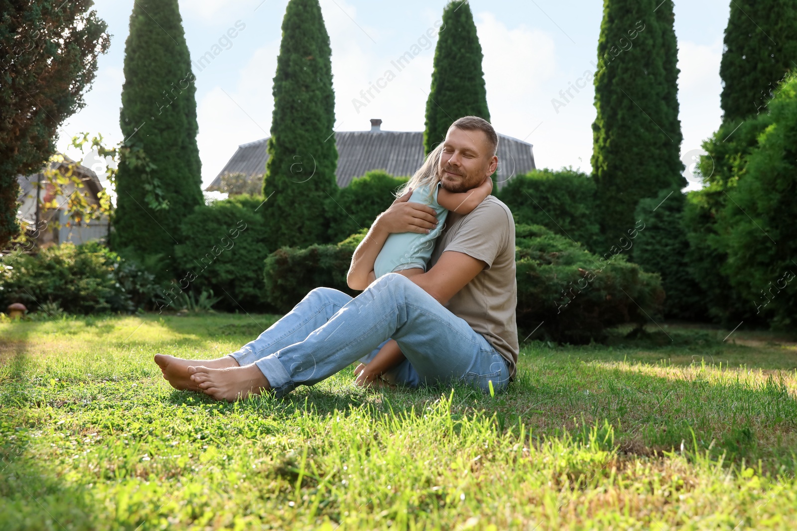 Photo of Father and his daughter spending time together on green lawn in park