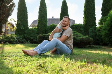 Father and his daughter spending time together on green lawn in park