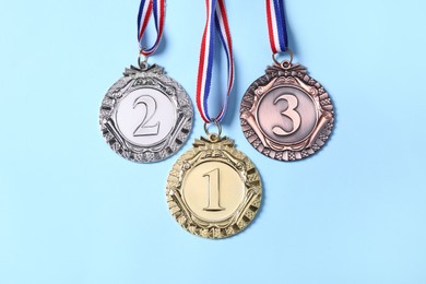 Photo of Different medals on light blue background, flat lay