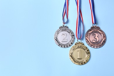 Photo of Different medals on light blue background, flat lay. Space for text