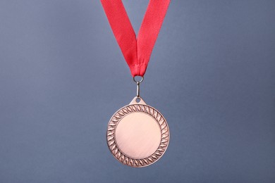 Photo of One bronze medal with ribbon on grey background