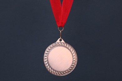 Photo of Bronze medal with red ribbon on dark grey background