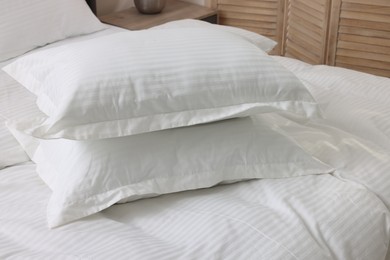 Bed with clean linens and pillows at home