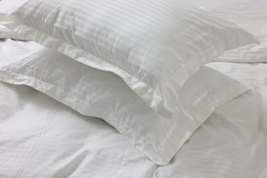 Photo of Bed with clean linens and pillows at home, closeup